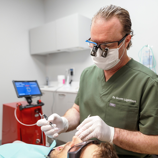 Periodontist treating a patient with a laser