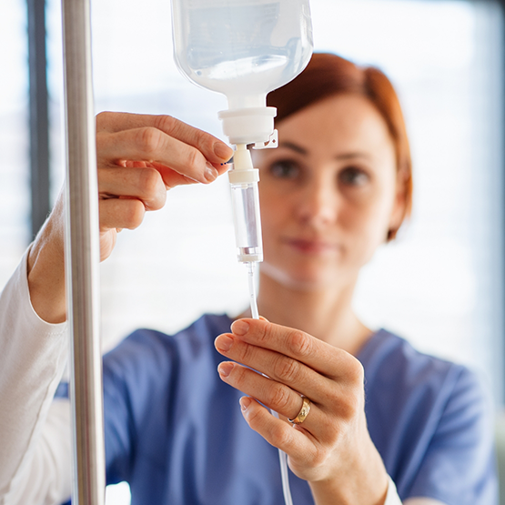 Nurse adjusting an IV drip