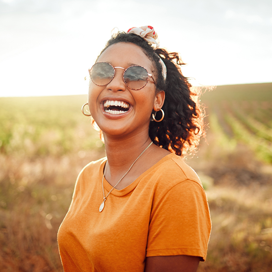 Woman with glasses grinning in the sun