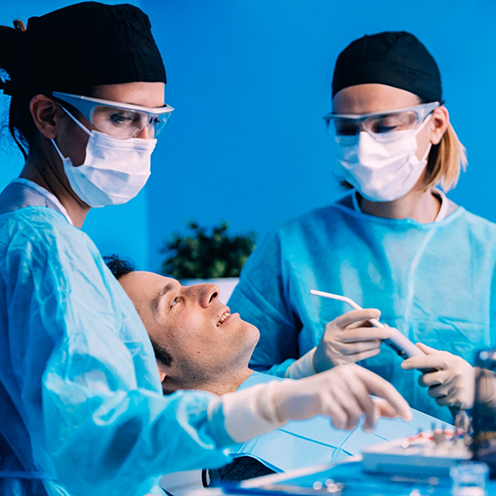 Periodontist and assistant treating a patient