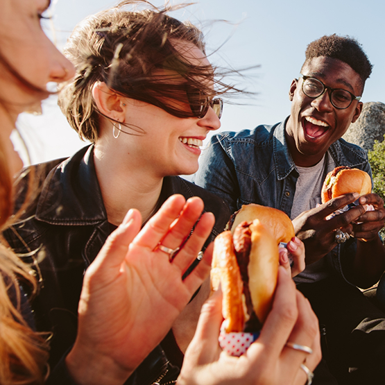 Young adults eating burgers outdoors