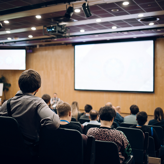 Lecture hall filled with students watching a presentation